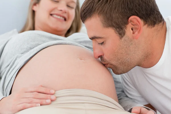 Close up de um futuro pai beijando a barriga de sua esposa — Fotografia de Stock