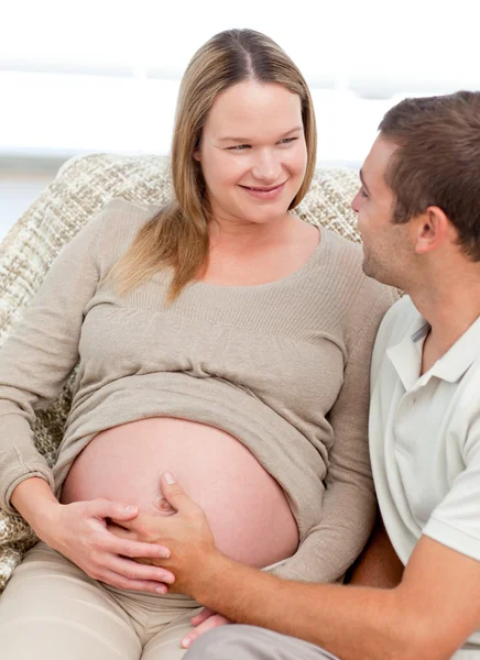Прекрасная беременная женщина трогает своего мужа за живот — стоковое фото
