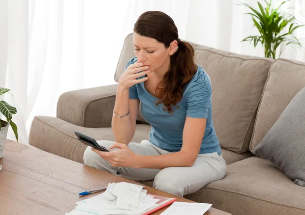 Mulher ansiosa calculando suas dívidas sentado na sala de estar — Fotografia de Stock