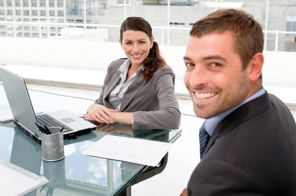 Zufriedene Geschäftsleute, die bei einem Meeting gemeinsam an einem Laptop arbeiten — Stockfoto