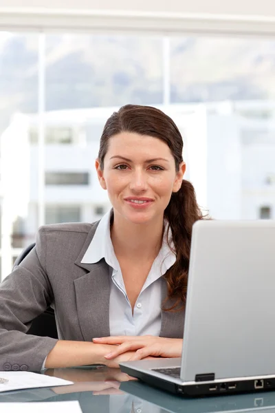 Mujer de negocios sonriente en el ordenador mirando a la cámara — Foto de Stock