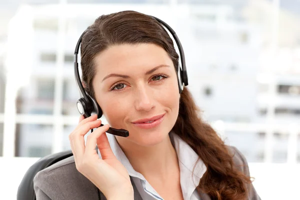 Pretty businesswoman with earpiece and looking at the camera — Stock Photo, Image