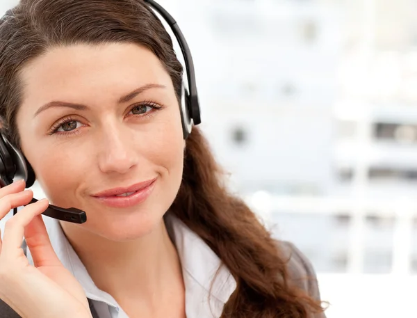 Pretty businesswoman with earpiece smiling at the camera — Stock Photo, Image