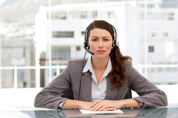 Aantrekkelijke zakenvrouw spreken via headset zittend op een tabblad — Stockfoto