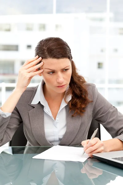 Empresária concentrada tomando notas enquanto trabalhava em seu colo — Fotografia de Stock