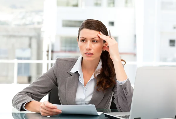 Mujer seria ejecutiva encontrando ideas mientras trabaja en su escritorio —  Fotos de Stock