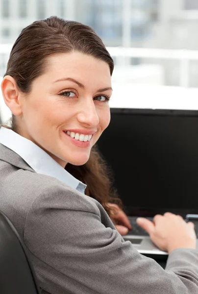Vista trasera de una mujer de negocios feliz trabajando en su computadora portátil — Foto de Stock