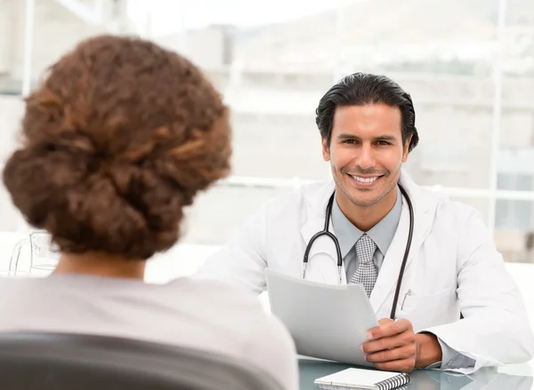 Vrolijke hispanic arts bij een afspraak met een patiënt — Stockfoto