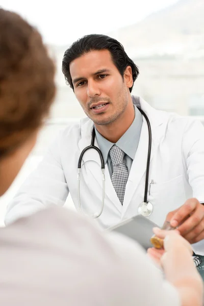 Medico serio che dà pillole al suo paziente durante un appuntamento — Foto Stock