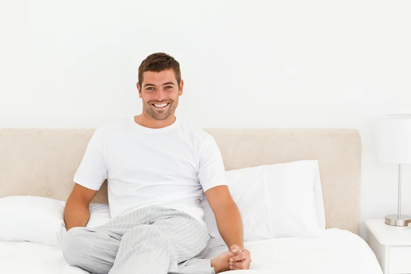 Homem feliz relaxando em sua cama em casa — Fotografia de Stock