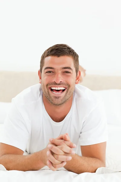 Portret van een vrolijke man ontspannen in zijn slaapkamer — Stockfoto