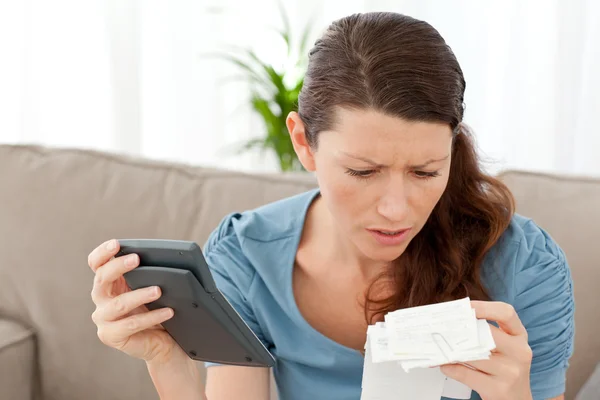 Worried woman calculating her bills in the living-room — Stock Photo, Image