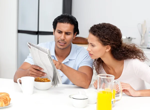 Uomo serio che mostra il giornale a sua moglie durante la colazione — Foto Stock