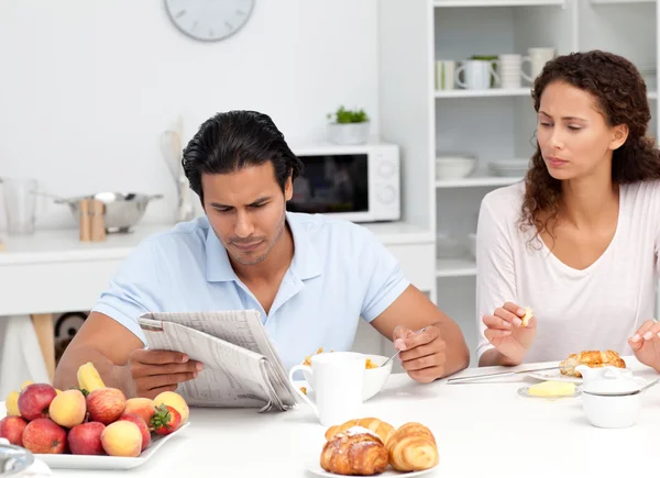Casal concentrado lendo o jornal juntos durante o café da manhã — Fotografia de Stock