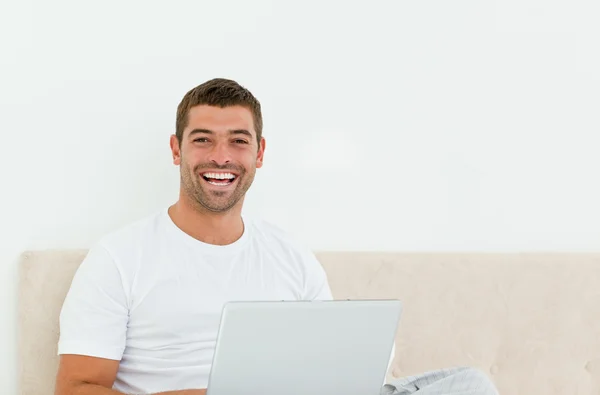 그의 침실에서 그의 노트북에서 일 하는 행복 한 사람 — 스톡 사진