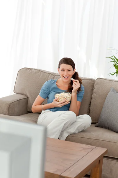 Mujer riendo mientras ve una película en la televisión en el livin — Foto de Stock