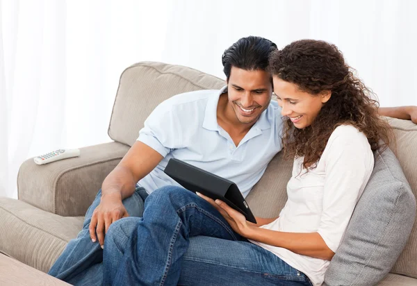 Bella coppia guardando video insieme seduti sul loro divano — Foto Stock