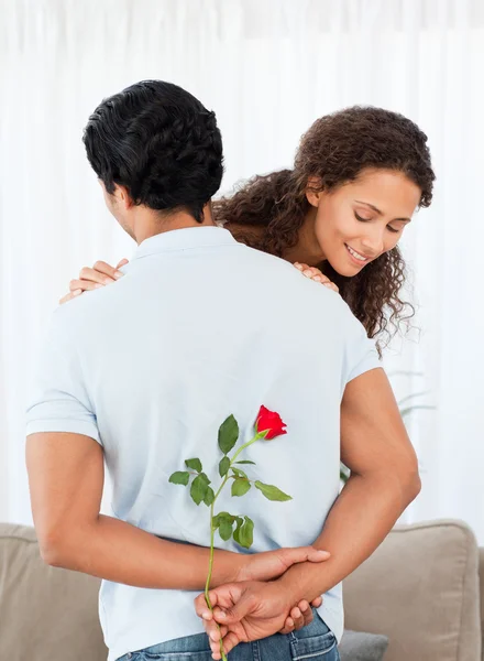 美丽的女人寻找隐藏他的男朋友的一朵玫瑰 — 图库照片