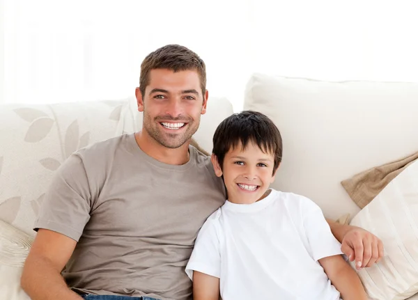 可爱的父亲和儿子坐在沙发上的肖像 — 图库照片