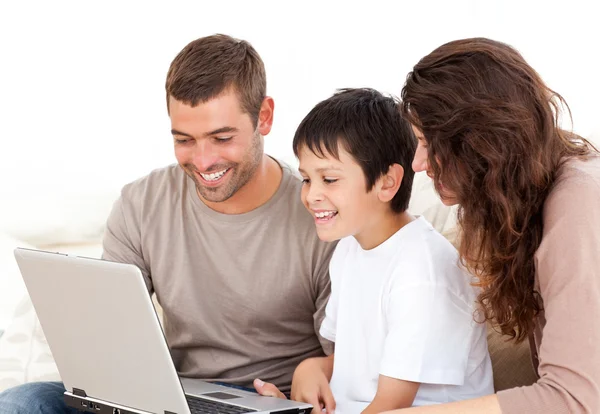 Ładny rodziny pracuje nad ich laptop razem siedzi na kanapie — Zdjęcie stockowe