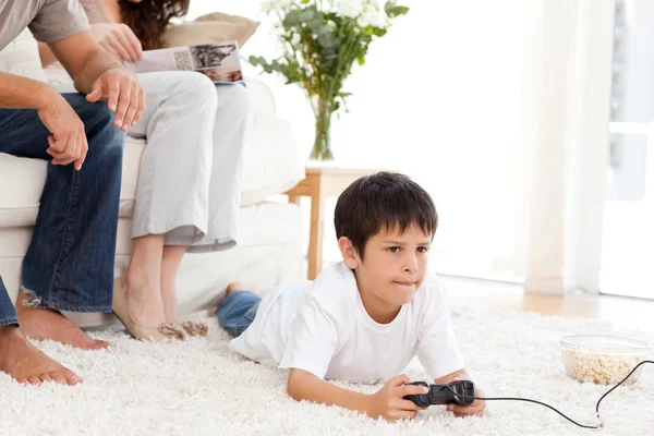 かわいい男の子の家の床に横たわっているビデオ ゲームをプレイ — ストック写真