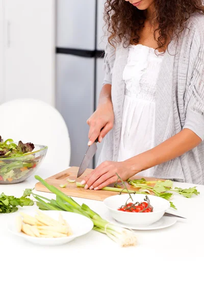 Close up de uma mulher cortando legumes na cozinha — Fotografia de Stock