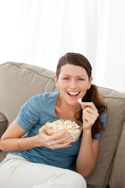 Portret van een gelukkige vrouw pop corn eten tijdens het kijken naar televi — Stockfoto
