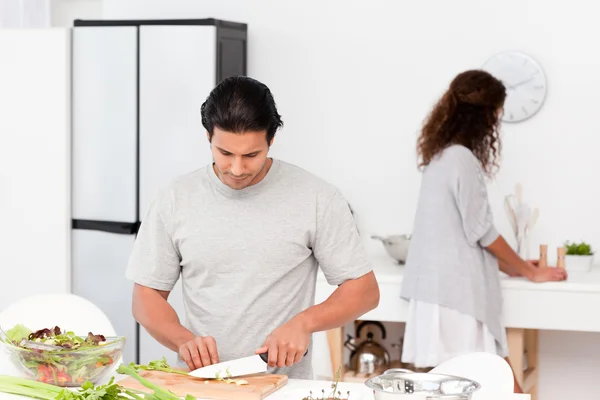 Hispanic couple preparing a salad together in the kitchen — Stock Photo, Image