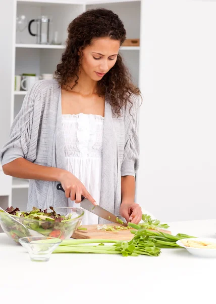 Härlig kvinna skära grönsaker i köket — Stockfoto