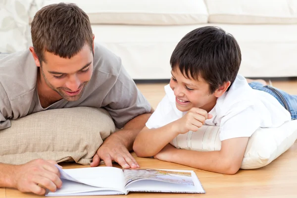 Ευτυχής πατέρας και γιος, διαβάζοντας ένα βιβλίο μαζί, στο πάτωμα — Φωτογραφία Αρχείου
