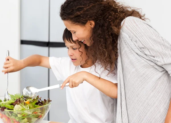 Gelukkig moeder en zoon een salade samen voorbereiden — Stockfoto