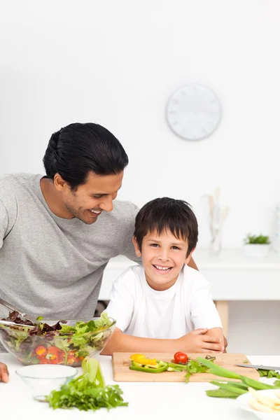 Lycklig far och son skära grönsaker tillsammans — Stockfoto