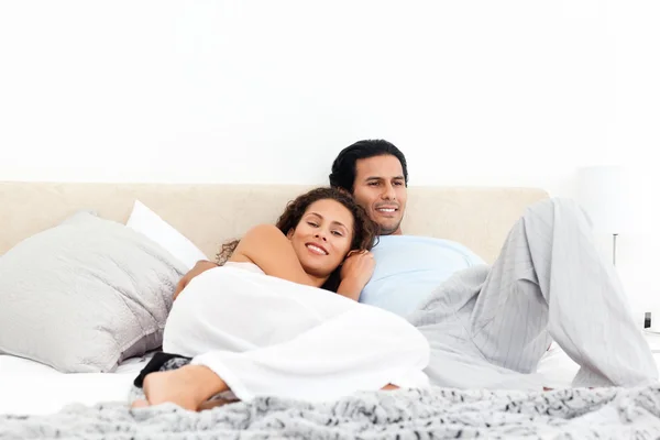 Lyckliga par avkopplande tillsammans på deras säng — Stockfoto