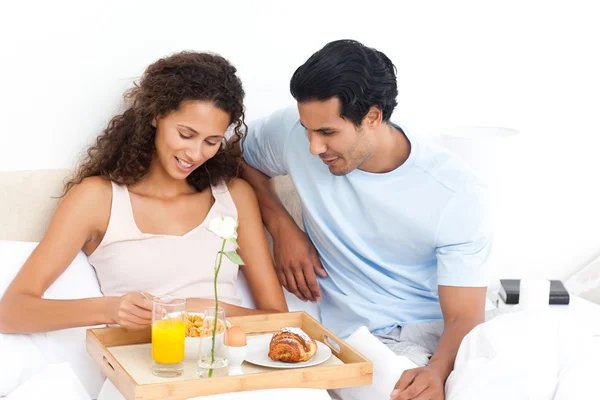 Niedliche Frau isst Müsli zum Frühstück liegend auf ihrem Bett — Stockfoto