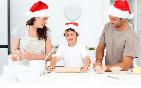 Fier parents regardant leur fils à l'aide d'un rouleau à pâtisserie — Photo