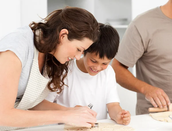 Happy family cooking biscuits together in the kitchen — Stock Photo, Image