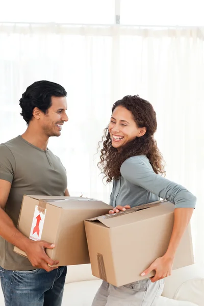 Lovely couple holding cardboards in their living-room — Stock Photo, Image