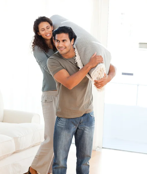 Homem e mulher carregando um tapete juntos — Fotografia de Stock