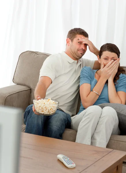 Terrified couple watching a horror movie — Stock Photo, Image
