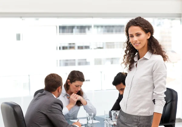 Attraktive Managerin steht im Büro, während ihr Team arbeitet — Stockfoto