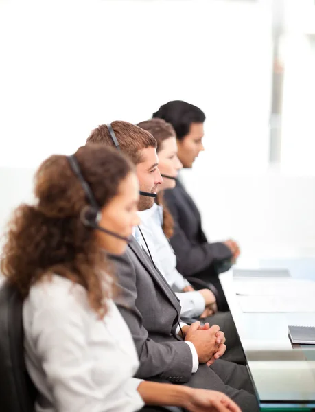 Quatro empresários ao telefone sentados em sua mesa — Fotografia de Stock