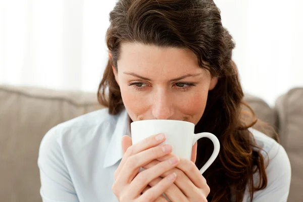 Hübsche Geschäftsfrau trinkt Kaffee auf dem Sofa — Stockfoto