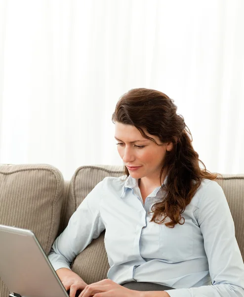 Güzel iş kadını kanepede onu laptop üzerinde çalışıyor — Stok fotoğraf