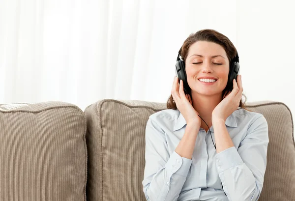 幸せな女性実業家のヘッドフォンで音楽を聴く — ストック写真