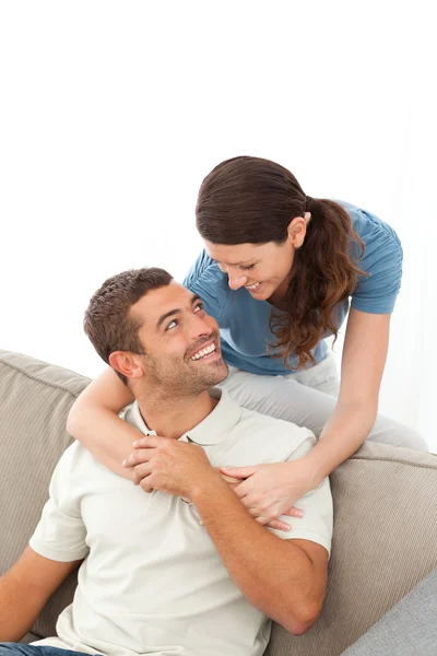 深情的女人在沙发上拥抱她丈夫放松 — 图库照片