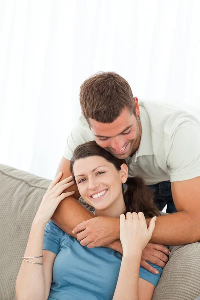 Retrato de um casal bonito abraçando na sala de estar — Fotografia de Stock