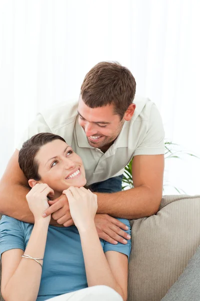 Tillgiven man talar med sin flickvän som sitter i soffan — Stock fotografie