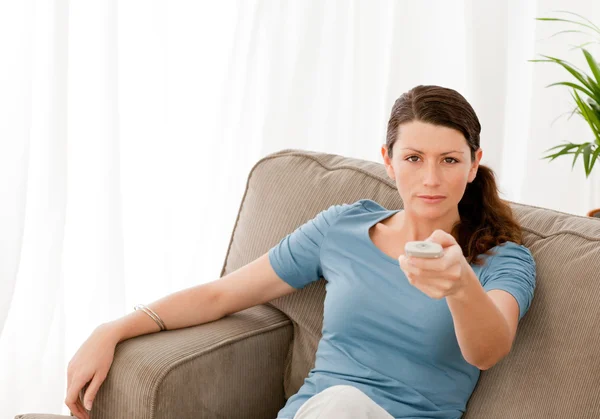 Karismatisk kvinna tittar på TV hemma — Stockfoto