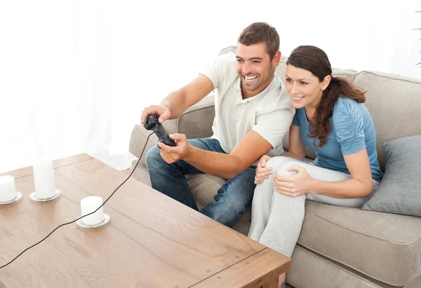Casal atencioso jogando videogame juntos na sala de estar — Fotografia de Stock