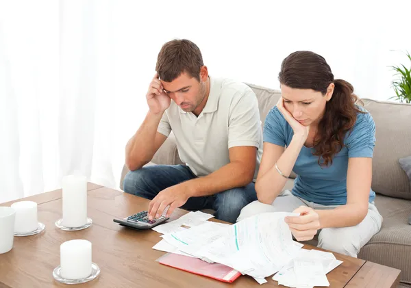 Desperate couple doing their accounts sitting on the sofa — Stock Photo, Image